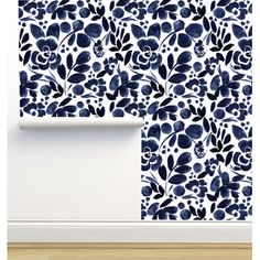 a blue and white wallpaper with flowers on it in an empty room next to a wooden floor