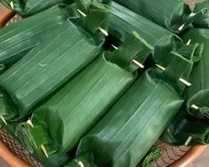 several pieces of green leafy food in a bowl