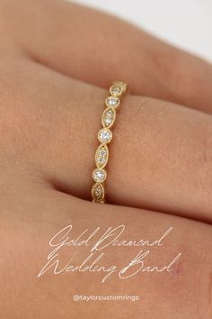 a woman's hand with a gold wedding band on top of her finger and the ring has five diamonds