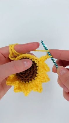 two hands crocheting the end of a sunflower