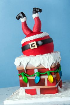 there is a cake made to look like santa claus on top of a brick wall