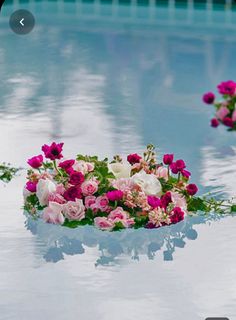 a pool party with pink and white flowers floating in the water on top of it