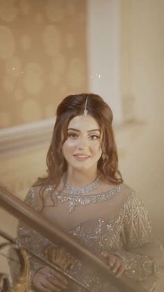 a woman in a dress is smiling and posing for the camera while standing on stairs