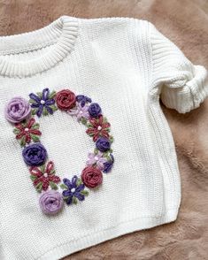 Handmade with love from Canada  This sweater is the perfect gift for a baby shower, birthday, holidays, or any milestone for a baby or toddler. Each sweater is 100% cotton and is hand embroidered with love and custom to your design and wishes. You can choose your sweater colour, yarn colours for your design and which flowers you want to make up your initial/number. Please indicate any custom requests in the personalization box. Personalization: Select your sweater colour between rose, white, and taupe as well as your size. Your sweater is 100% cotton and has an oversized fit. Choose your yarn colours. Refer to photos to see options.  When entering your personalization, ensure you provide all the necessary details including which flowers you'd like: roses, daises, leaves etc. I will contact Baby Sweater Embroidery, Sweater Ideas, Embroidery Sweater, Embroidery Gifts, Embroidered Monogram, Knit Sweaters, Custom Initials, Baby Cardigan, Embroidery Ideas