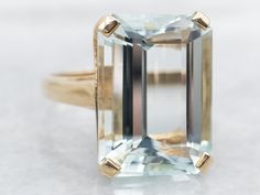 an aquamarinee colored diamond ring with gold accents