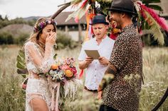 a man and woman standing next to each other in front of a wedding ceremony arch