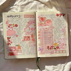 an open book with pink and red designs on it, sitting on a white sheet