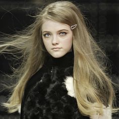 a model with long blonde hair on the catwalk wearing a black and white fur coat