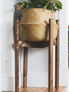 a basket sitting on top of a wooden chair next to a planter with flowers in it