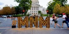 people walking past the state capitol building in washington d c, with mardi gras lights