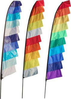 three rainbow colored flags with black poles on each side and one has a white background