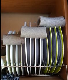 there are many different colored surfboards on the shelf in this cabinet, all stacked together