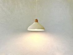 a white wall with a light hanging from it