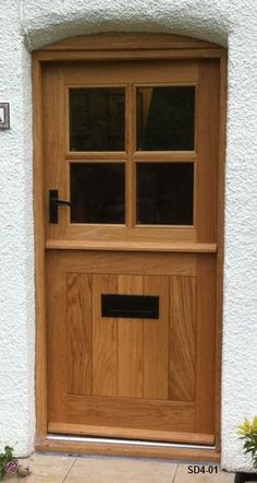 a wooden door on the side of a white building