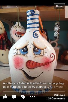 a vase with a face painted on it sitting in front of some other items and toys