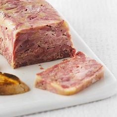 a piece of meat sitting on top of a white plate next to some potato wedges