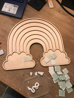 a wooden cutout of a rainbow surrounded by broken glass tiles and other crafting supplies