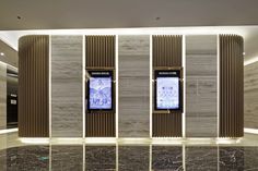 an elevator in a building with marble walls and flooring that has vertical panels on the wall