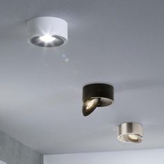 three lights that are on the ceiling in a room