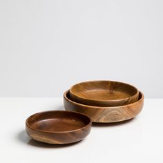 two wooden bowls sitting next to each other