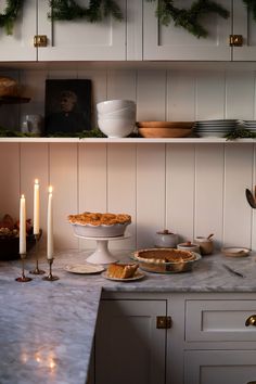 the kitchen counter is covered with dishes and candles