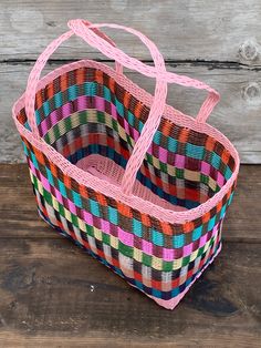 a multicolored basket sitting on top of a wooden table