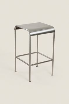 a metal stool with a square seat on the bottom and one foot in the middle