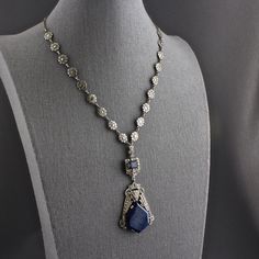 This is an absolutely spectacular Art Deco sterling silver genuine lapis lazuli marcasite daisy chain choker drop pendant necklace from Germany. The silver necklace has an open silver link chain at each end and a decorative nine link marcasite daisy flower chain. In the center is a bail from which a three dimensional panel is suspended that is covered in marcasites, and has a rectangular piece of deep blue lapis. Attached to that is a large sterling pendant with an elongated hexagonal piece of t Art Deco White Gold Necklace With Gemstone, Art Deco White Gold Gemstone Necklace, White Gold Art Deco Gemstone Necklace, Art Deco White Gold Jewelry With Cabochon, Luxury Lapis Lazuli Cabochon Jewelry, Elegant Sapphire Necklaces With Natural Stones, Exquisite Sapphire Pendant Necklace, Elegant Lapis Lazuli Gemstone Necklace, Elegant Lapis Lazuli Natural Stone Necklace