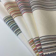 four pieces of fabric with different colors and patterns on the top one is white, red, green, blue, yellow