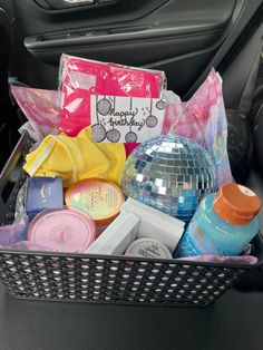 a basket filled with lots of different items in the back seat of a car next to a mirror