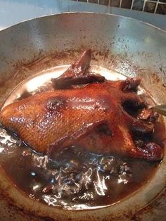 a chicken is cooking in a pan on the stove