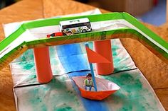 a paper boat on top of a table with a green and white cover over it