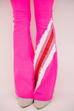 Get ready to stand out in these SEASON'S GREETINGS PINK FLARES! The flared fit and pink color will make you the life of the party. And who can resist the white fur and red and pink glitter striped ribbon design on the leg? A must-have for holiday celebrations (and for those who love to make a statement)! All orders are currently shipping within 14 business days. To receive item quicker, expedited shipping is available at checkout. Pink Wide Leg Winter Pants, Pink Wide Leg Pants For Winter, Trendy Fitted Pink Flares, Pink Wide Leg Flares For Spring, Pink Flare Bottoms For Spring, Trendy Pink Winter Pants, Pink Fitted Wide Leg Flares, Spring Stretch Pink Flares, Trendy Pink Winter Bottoms