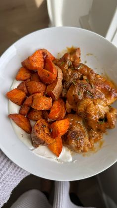 a white plate topped with meat and sweet potatoes