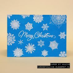 a blue christmas card with snowflakes on it