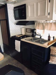 a kitchen with black cabinets and white walls