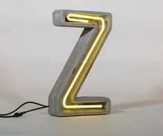 a neon yellow z sign sitting on top of a white table next to a black cord