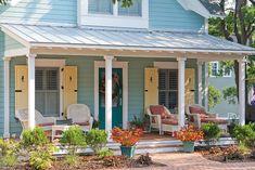 a blue house with white trim and yellow shutters on the front door is shown