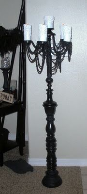 a black candelabra with candles on it in front of a white door