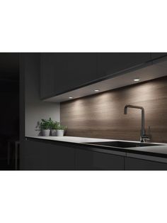 a modern kitchen with black cabinets and white counter tops is illuminated by recessed lighting