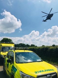 two ambulances and a helicopter flying in the sky