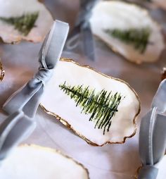 decorated cookies with trees on them and ribbon tied around the edges, sitting on a table