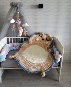 a crocheted blanket sitting on top of a wooden bench next to a stuffed animal