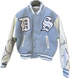 A varsity bomber jacket is a type of outerwear that is typically associated with American collegiate and sports culture. It draws inspiration from traditional letterman jackets worn by varsity athletes. The jacket is characterized by its casual and athletic design, often featuring a snap-button front closure, ribbed collar, cuffs, and waistband. The varsity bomber jacket is usually made of durable materials such as wool or nylon, providing warmth and protection from the elements. The body of the Varsity Jacket With Letter Embroidery, Hip Hop Varsity Jacket With Ribbed Cuffs For Fall, Hooded Varsity Jacket With Letter Embroidery For Fall, Winter Hip Hop Varsity Jacket For Streetwear, Fall Hooded Varsity Jacket With Letter Embroidery, White Varsity Outerwear With Letter Embroidery, Hip Hop Varsity Jacket For College In Fall, White Varsity Jacket With Embroidered Logo For Streetwear, Cotton Outerwear For Streetwear During Baseball Season