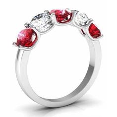 a three stone ring with red and white stones on the sides, set in 18k white gold