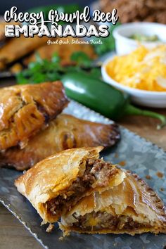 some food is laying out on a table with other foods in the background and text overlay that reads cheesy brunch beef empanadas