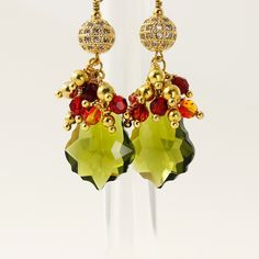 Any time...Any where...Any way...satiate your senses... A beautiful and elegance earrings. These earrings look beautiful and you can wear with almost anything. ...Baroque Olivine Premium Quality Crystal (22 mm) bead... ...faceted round Fire Opal and Siam Premium Quality Crystal (4 mm)bead... ...round gold plated metal bead (8 mm) studded with Clear Cubic Zirconia... ...French hook gold plated brass lever back ear wires... These earrings measures about 2 3/8" including ear wires. These earrings a Earrings Funny, Recycled Gifts, Organza Pouch, Metal Bead, Detailed Jewelry, Red Crystals, Jewelry Women, Cluster Earrings, Metal Beads