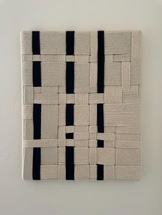 a black and white wall hanging on the side of a wall with squares in it