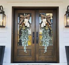 two wreaths on the front door of a house