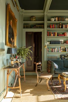 a living room filled with furniture and bookshelves next to a painting on the wall